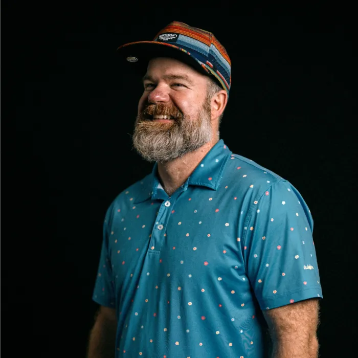 Brandon M. Haubert, founder of ArkansasLegalNow, smiling in a striped cap and blue patterned polo shirt